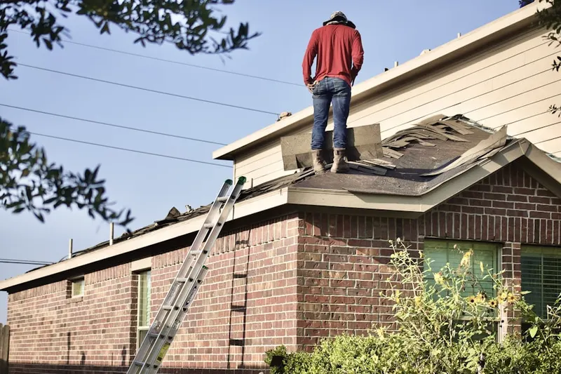 Professional roofer working on a residential roof in Ancora
